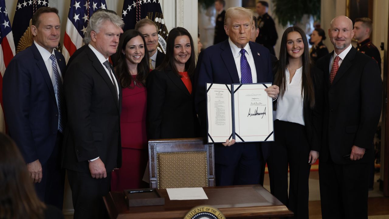 WASHINGTON, DC - JANUARY 29: Surrounded by  of Congress and the family of Laken Riley, U.S. President Donald Trump poses with the signed Laken Riley Act, the first piece of legislation ed during his second term in office, in the East Room of the White House on January 29, 2025 in Washington, DC. Jason Riley and Allyson Philips, the parents of 22-year-old Laken Riley, a University of Georgia nursing student who was murdered in 2024 by an undocumented immigrant, attended the g ceremony. Among other measures, the law directs law enforcement authorities to detain and deport immigrants who are accused but not yet convicted of specific crimes, if they are in the country illegally. (Photo by Chip Somodevilla/Getty Images)