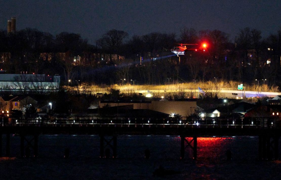 A helicopter assists with search and rescue operations over the Potomac river near Ronald Reagan Washington Airport