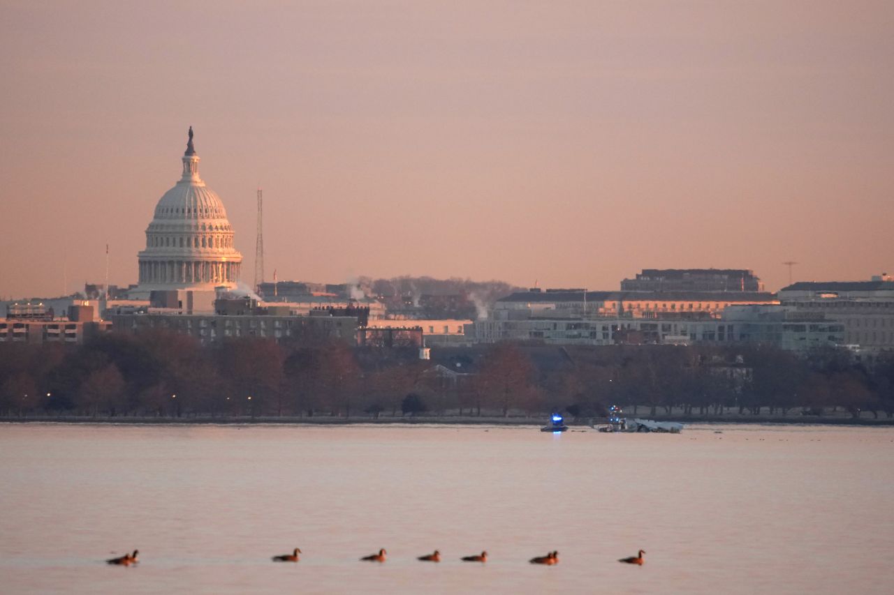 The Capitol Building is seen in the background as emergency response units search the crash site of an American Airlines plane on the Potomac River in Arlington, Virginia on Thursday.