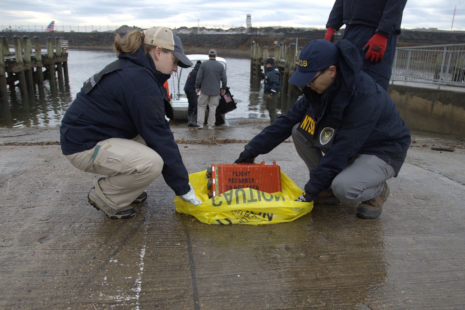 Investigators with the National Transportation Safety Board prepare to transport a combination flight data and cockpit voice recorder on Sunday. It was from the Black Hawk helicopter involved in the collision.