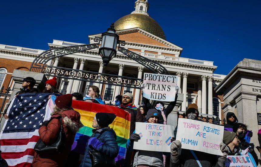 Demonstrators hold signs supporting transgender rights during a rally outside the Massachusetts State House in Boston on January 30.