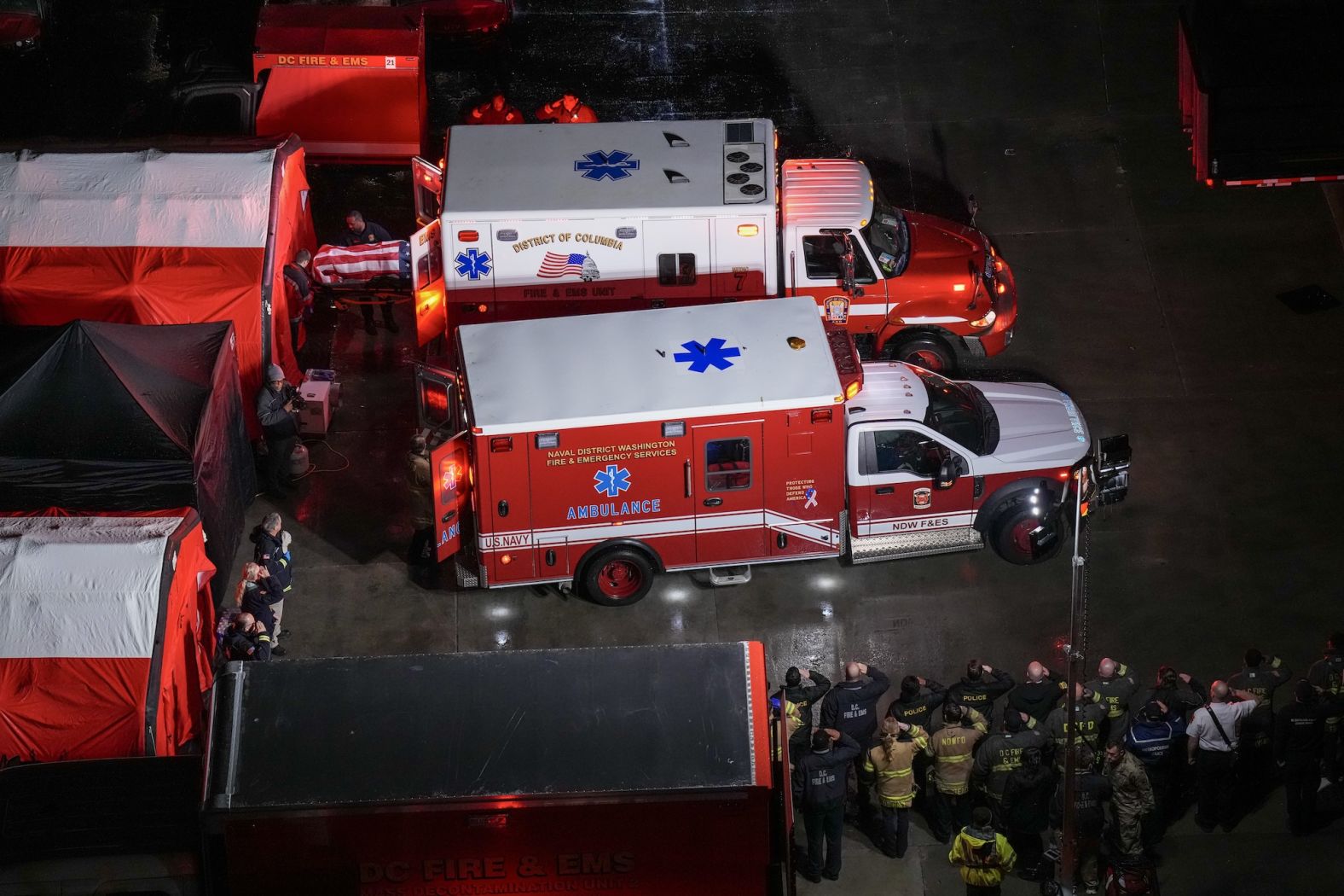 First responders in Washington, DC, salute the flag-draped coffins of service members on Friday, January 31.