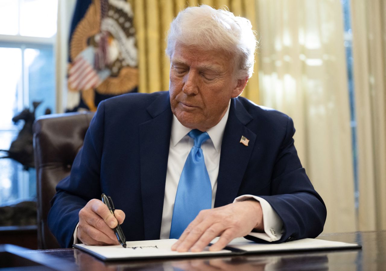 President Donald Trump signs an executive order in the Oval Office of the White House on Tuesday.