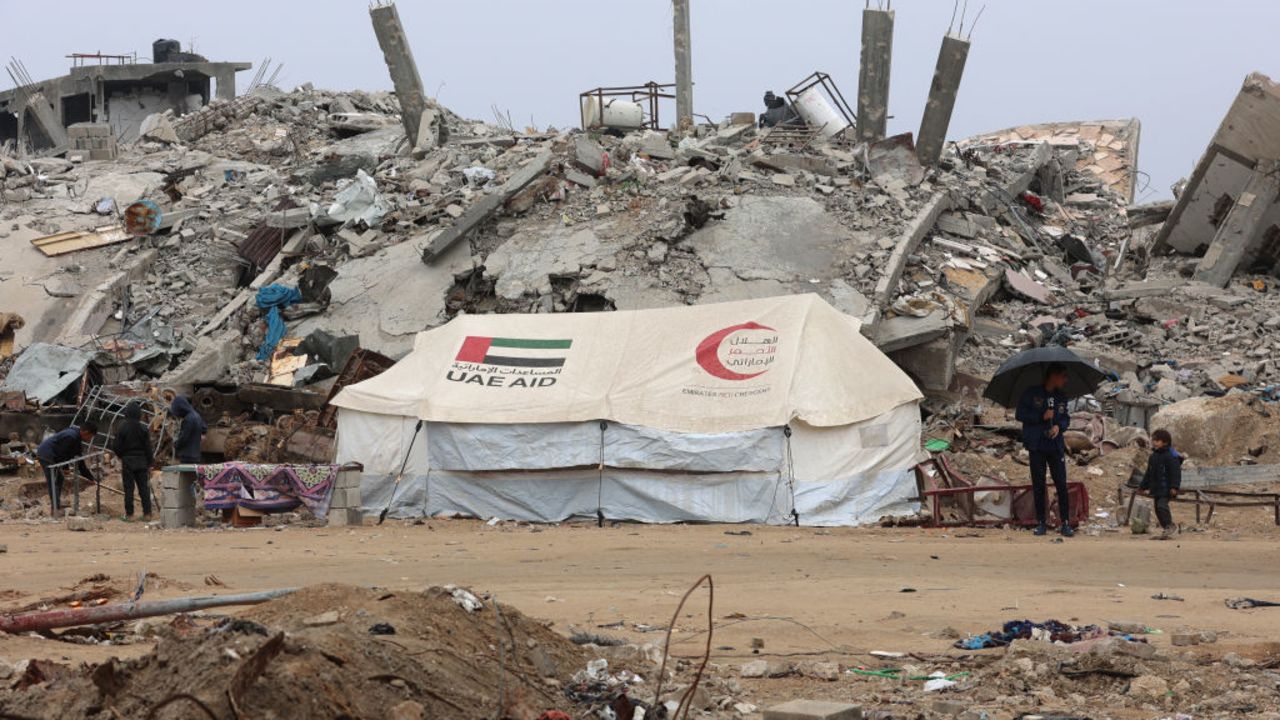 A UAE AID tent stands in front of a collapsed building at Saftawi street in Jabalia in the northern Gaza Strip on February 5, 2025, during a ceasefire deal in the war between Israel and Hamas. Palestinian militant group Hamas lashed out on February 5, at President Donald Trump's shock proposal for the United States to take over the Gaza Strip and resettle its people in other countries, seemingly whether they want to leave or not. (Photo by Omar AL-QATTAA / AFP) (Photo by OMAR AL-QATTAA/AFP via Getty Images)