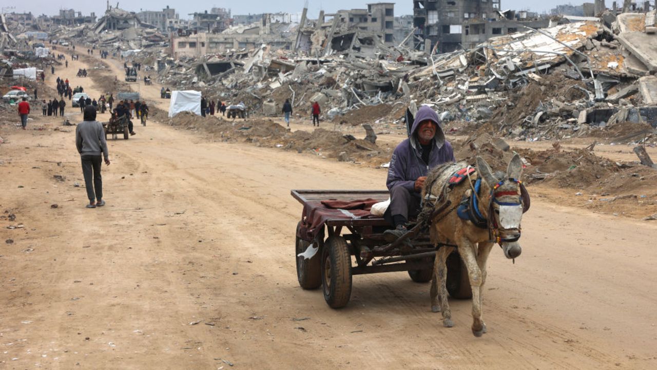 TOPSHOT - A man rides a donkey-pulled cart past the rubble of destroyed buildings at Saftawi street in Jabalia, in the northern Gaza Strip, on February 5, 2025 during a ceasefire deal in the war between Israel and Hamas. Palestinian militant group Hamas lashed out on February 5, at President Donald Trump's shock proposal for the United States to take over the Gaza Strip and resettle its people in other countries, seemingly whether they want to leave or not. (Photo by Omar AL-QATTAA / AFP) (Photo by OMAR AL-QATTAA/AFP via Getty Images)