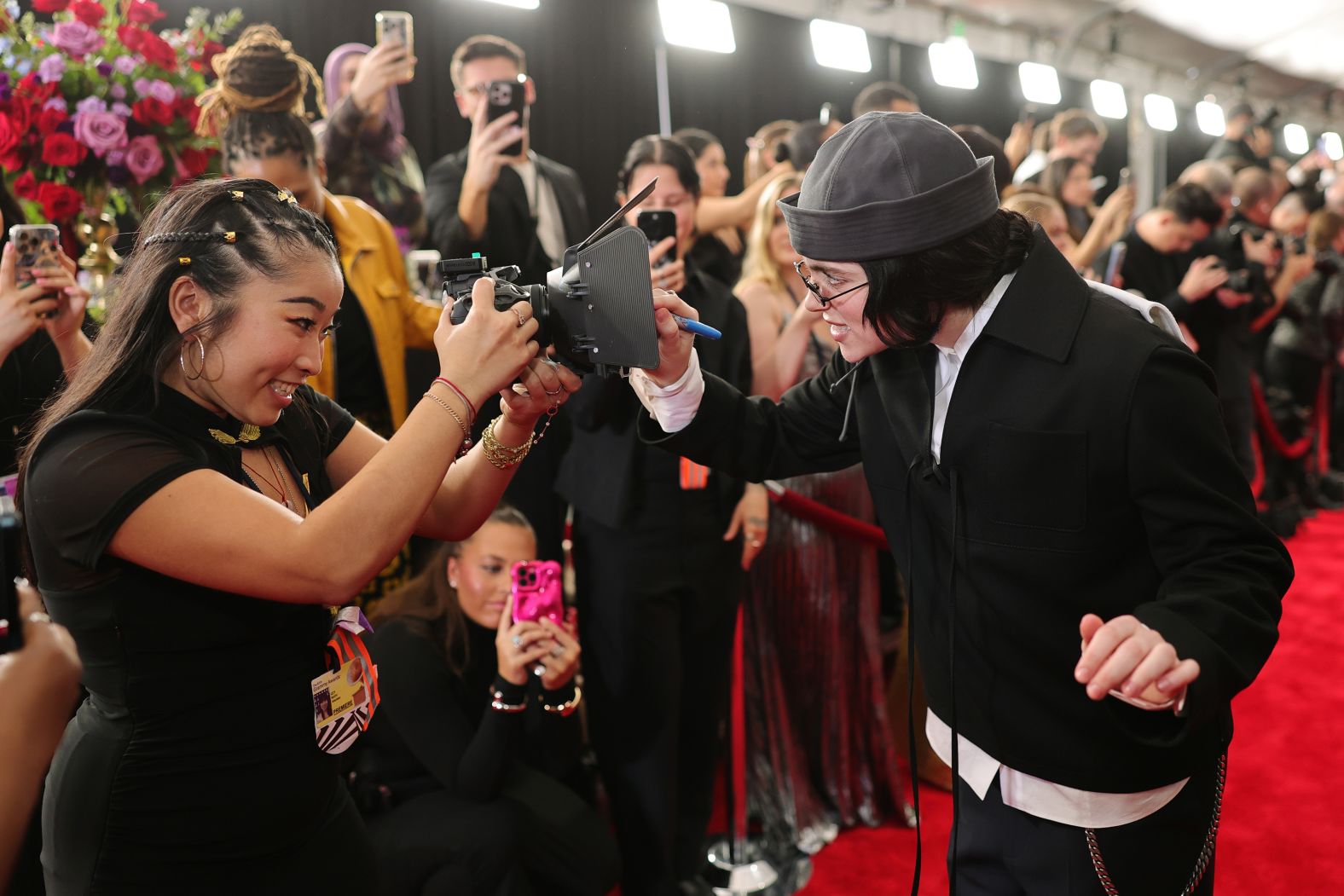 Billie Eilish signs a camera on the red carpet before the start of the show on Sunday.