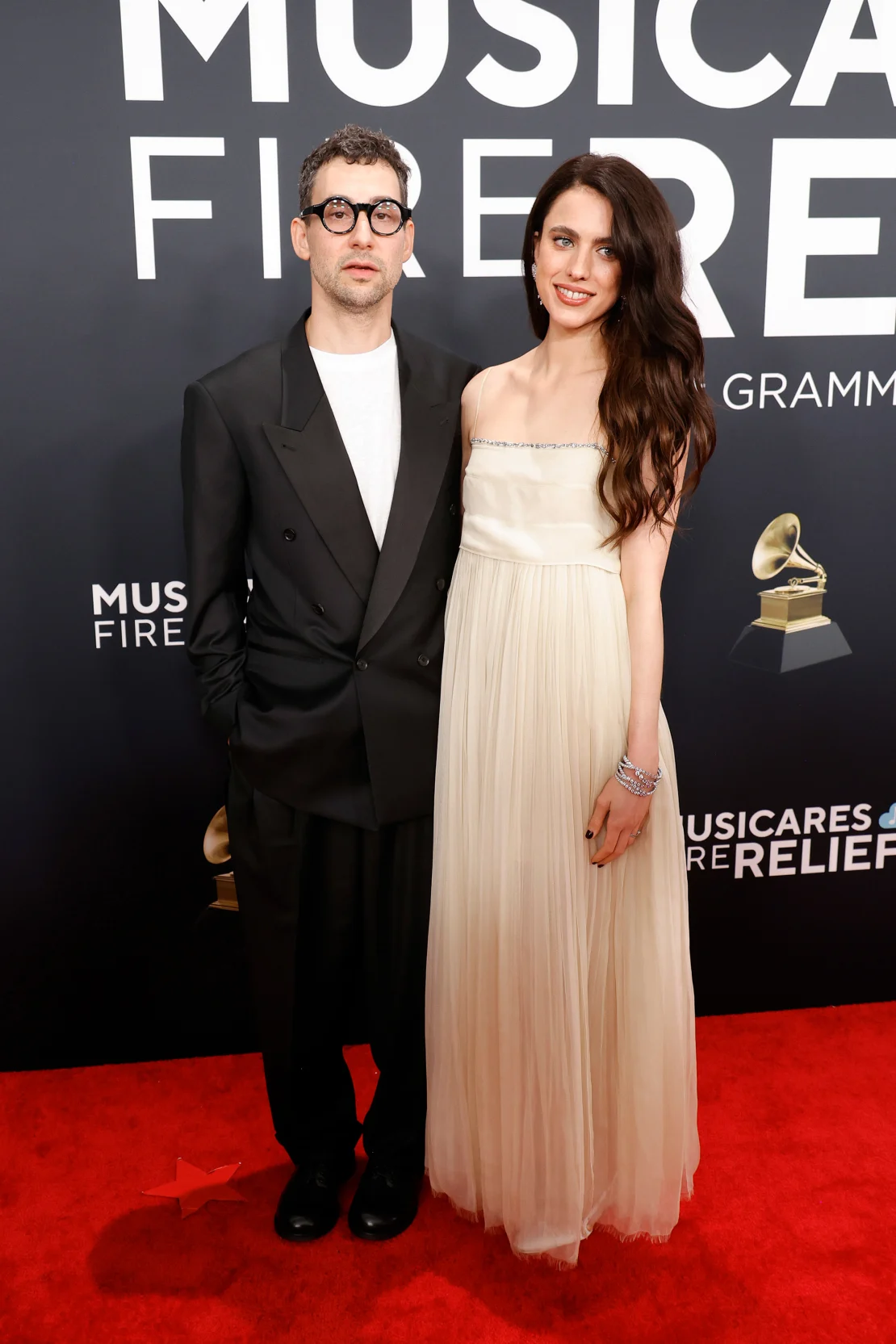 Jack Antonoff, who racked up six nominations for his work with Taylor Swift and Sabrina Carpenter, poses with wife Margaret Qualley, who wore a vintage embroidered ivory dress by Chanel. Frazer Harrison/Getty Images