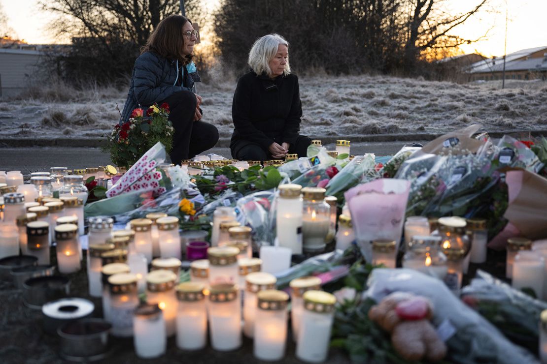 People light candles at a makeshift vigil Thursday near the scene of the shooting.