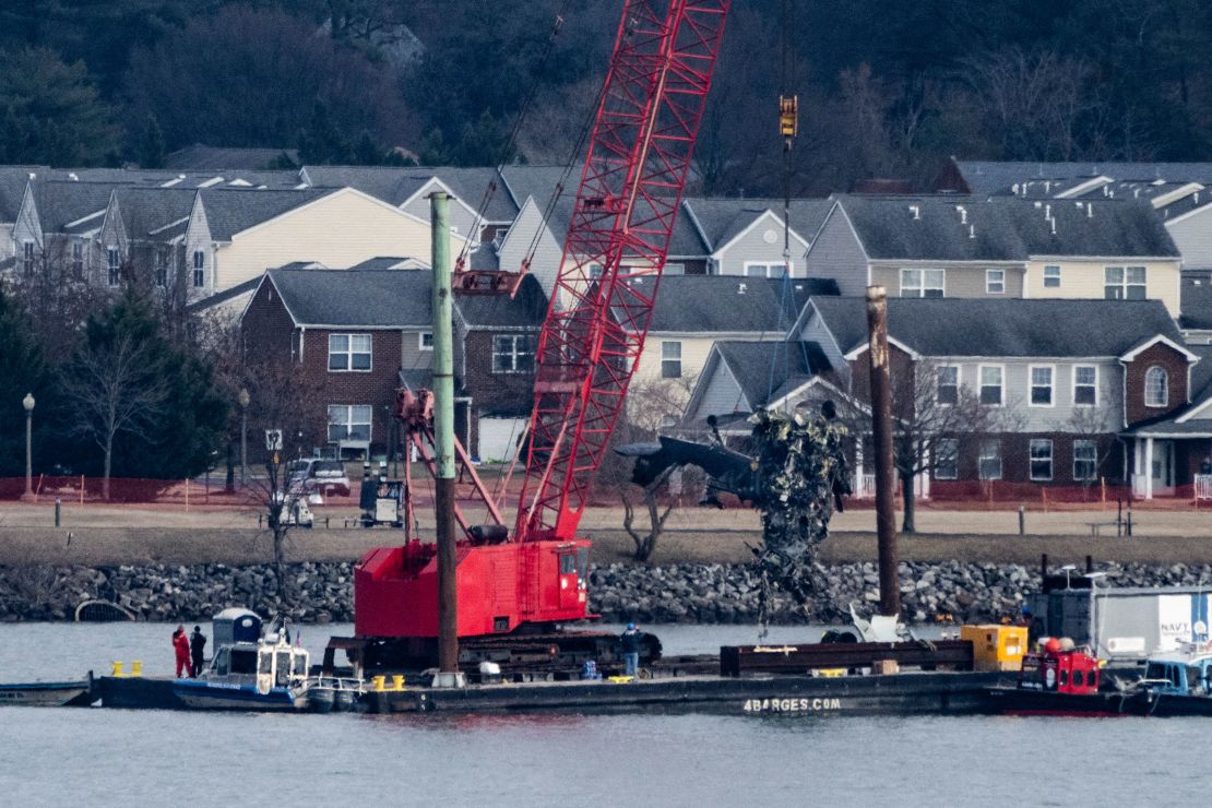 Recovery teams lift the mangled remains of a military helicopter that crashed midair with an American Airlines commercial airplane from the Potomac river in Arlington, Virginia, on February 6.