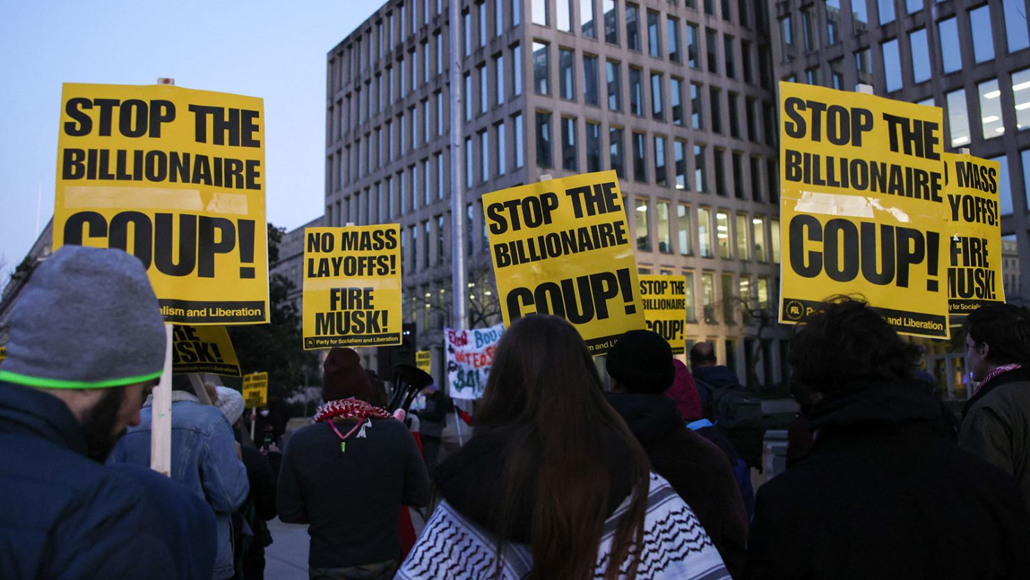 Demonstrators gather outside of the Office of Personnel Management in Washington, DC, on February 7, 2025, to protest federal layoffs and demand the termination of Elon Musk from the Department of Government Efficiency (DOGE).