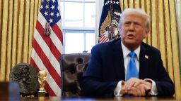 The 2026 men's FIFA World Cup trophy is visible behind US President Donald Trump as he speaks with reporters before signing two executive orders in the Oval Office of the White House on February 4.