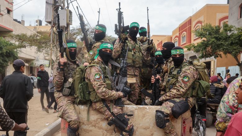 TOPSHOT - Hamas fighters patrol a street before they handover three Israeli hostages to a Red Cross team in Deir el-Balah, central Gaza, on February 8, 2025. Hamas militants handed over three Israeli hostages on February 8, as part of the fifth exchange under a fragile Gaza ceasefire, with 183 prisoners held by Israel due to be released later in the day. (Photo by Eyad BABA / AFP) (Photo by EYAD BABA/AFP via Getty Images)          
