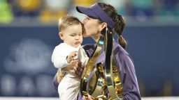 Switzerland's Belinda Bencic celebrates with her daughter and the trophy after defeating Ashlyn Krueger of the US during the women's final singles match at the Abu Dhabi Open tennis tournament on February 8, 2025.