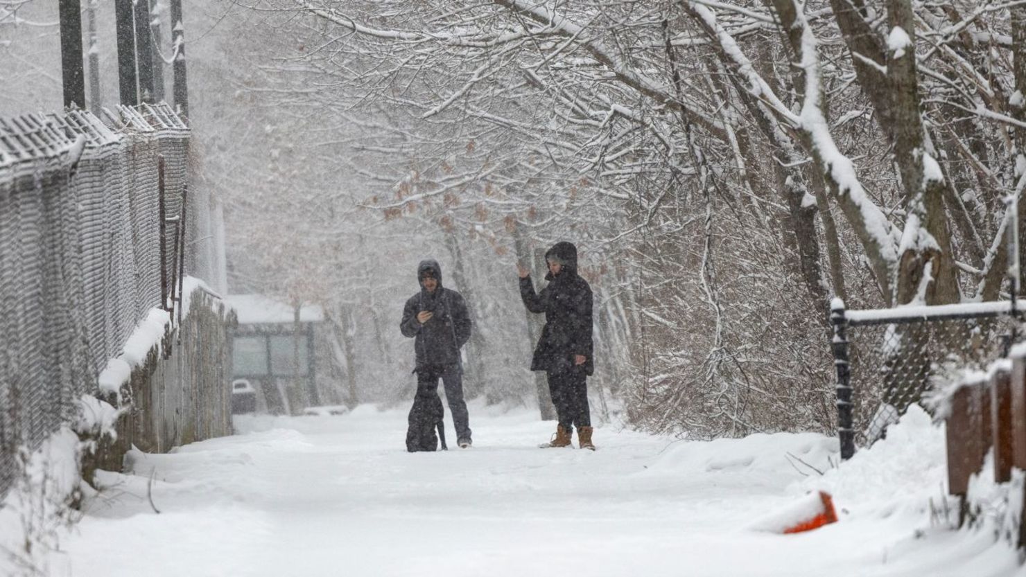 Gente pasea a un perro por la nieve el domingo en Boston, Massachusetts.