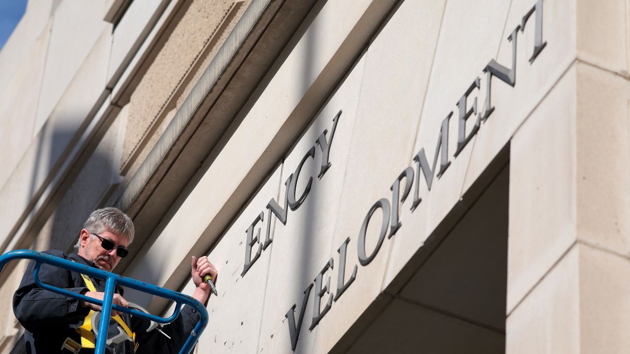 WASHINGTON, DC - FEBRUARY 07: A worker removes the U.S. Agency for International Development sign on their headquarters on February 07, 2025 in Washington, DC. President Donald Trump and Elon Musk's Department of Government Efficiency (DOGE) abruptly shutdown the U.S. aid agency earlier this week leaving thousands unemployed and putting U.S. foreign diplomacy and aid programs in limbo.  (Photo by Kayla Bartkowski/Getty Images)