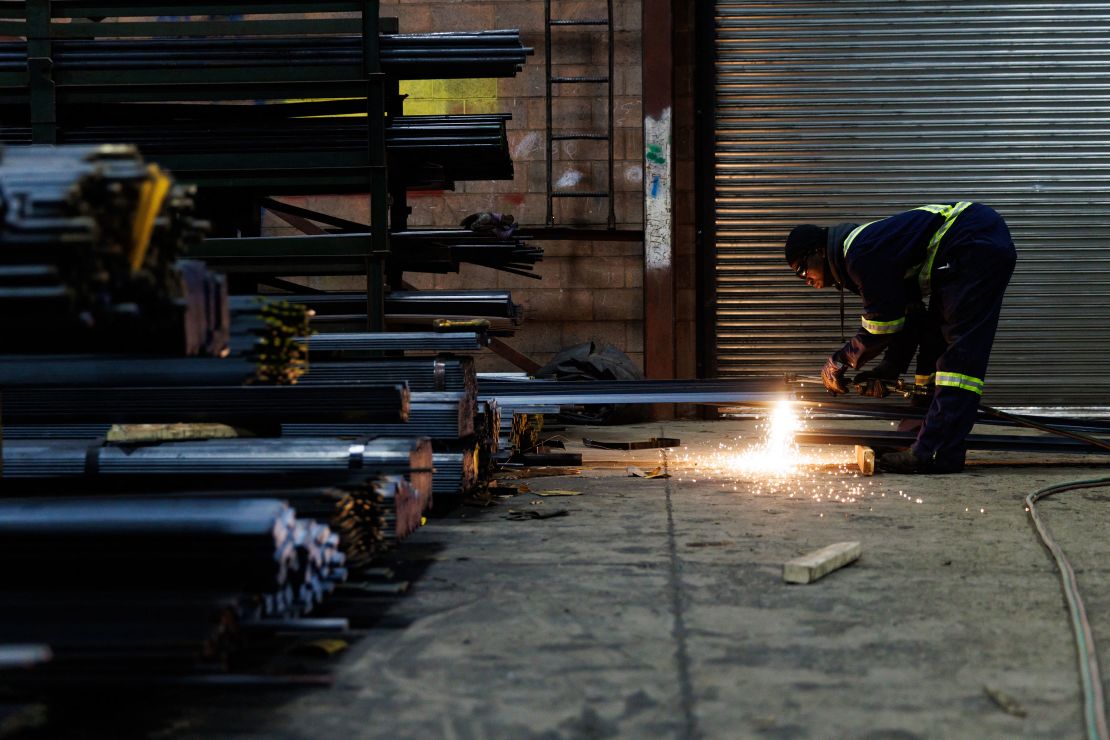 A worker cuts a piece of steel.