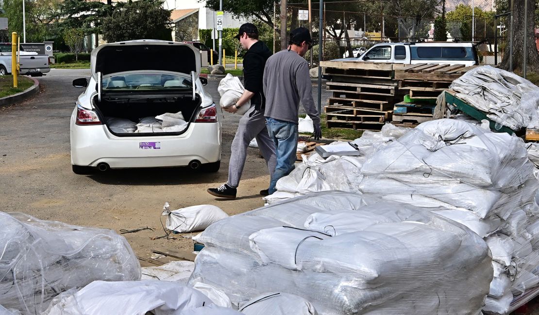 People load sandbags into the trunk of car in Pasadena, California, Wednesday.