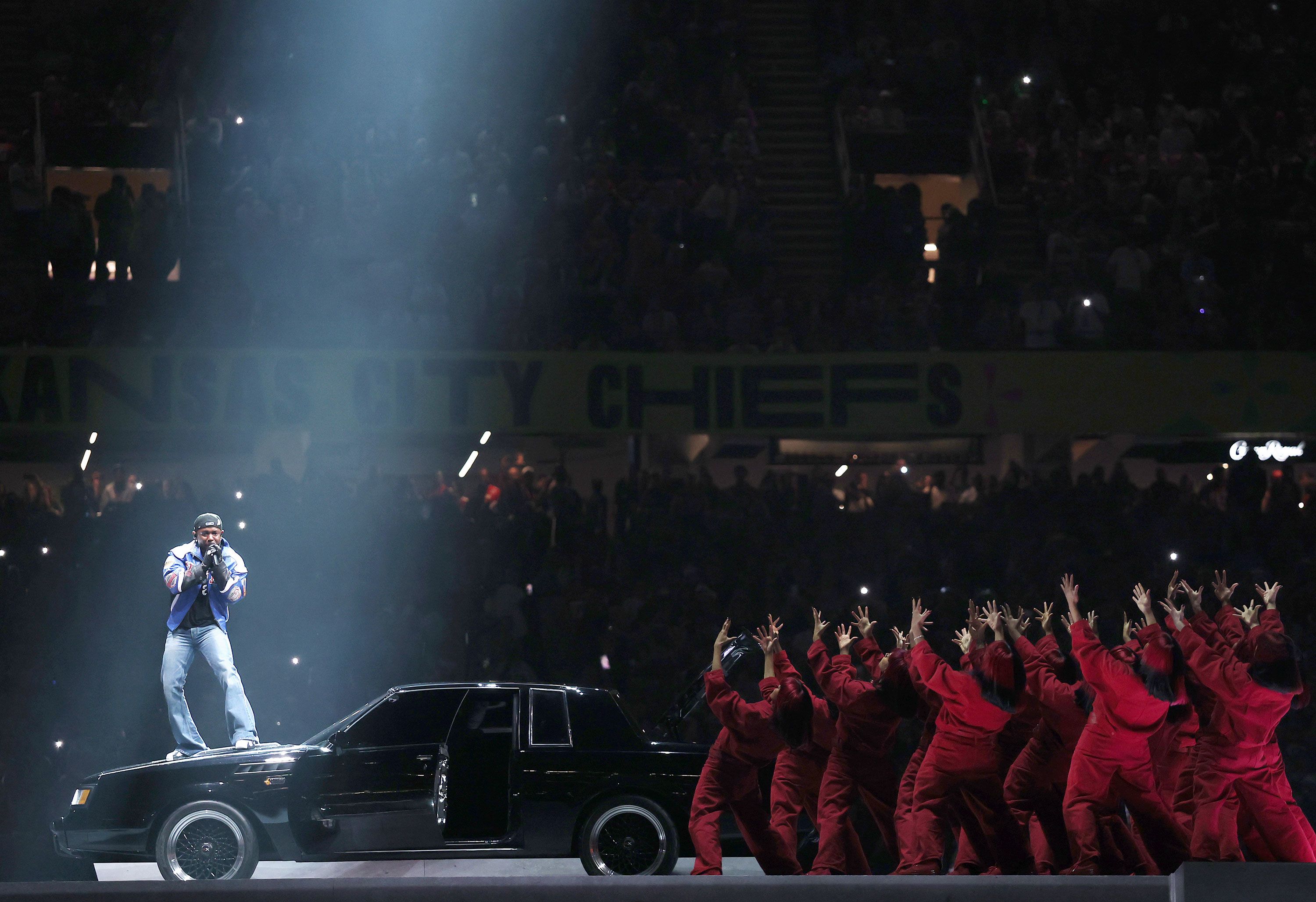 Kendrick Lamar opens his Super Bowl halftime show on the hood of a car on Sunday, February 9.