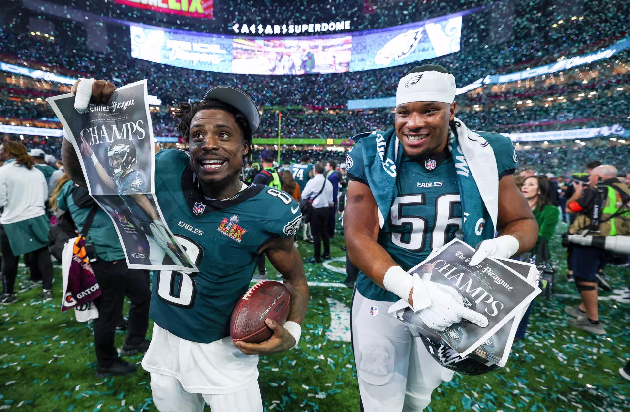 Safety CJ Gardner-Johnson and linebacker Jalyx Hunt celebrate with newspapers.