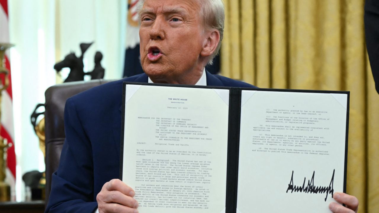 El presidente de Estados Unidos, Donald Trump, habla mientras muestra la acción ejecutiva sobre aranceles recíprocos que firmó en el Despacho Oval de la Casa Blanca en la ciudad de Washington, el 13 de febrero de 2025. 