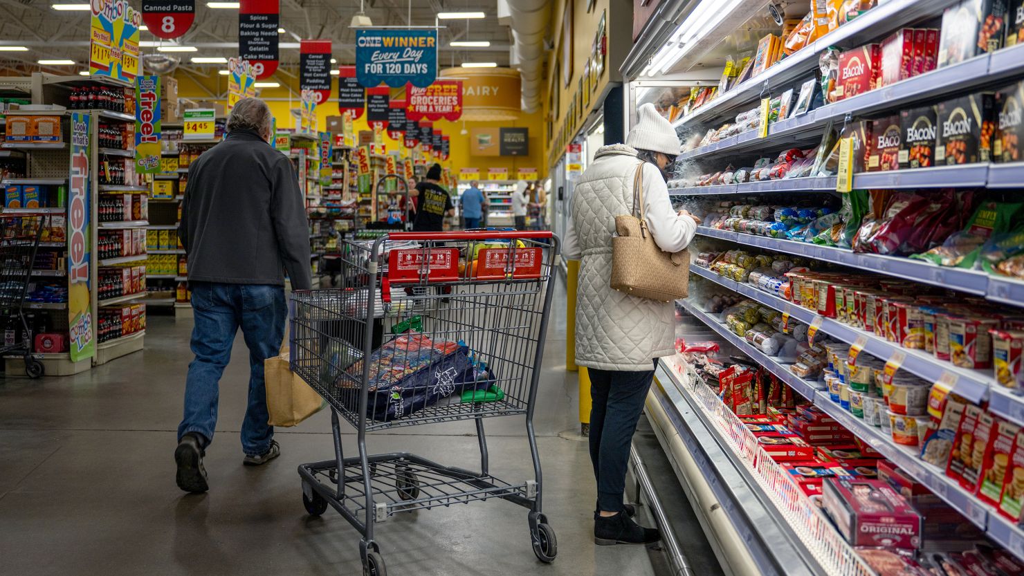 Customers shop for produce at a grocery store.