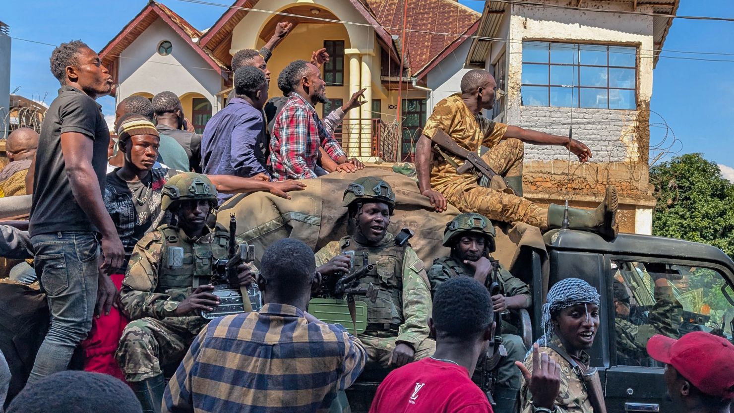 Residents walk next to a vehicle with M23 fighters on in Bukavu, February 16, 2025.