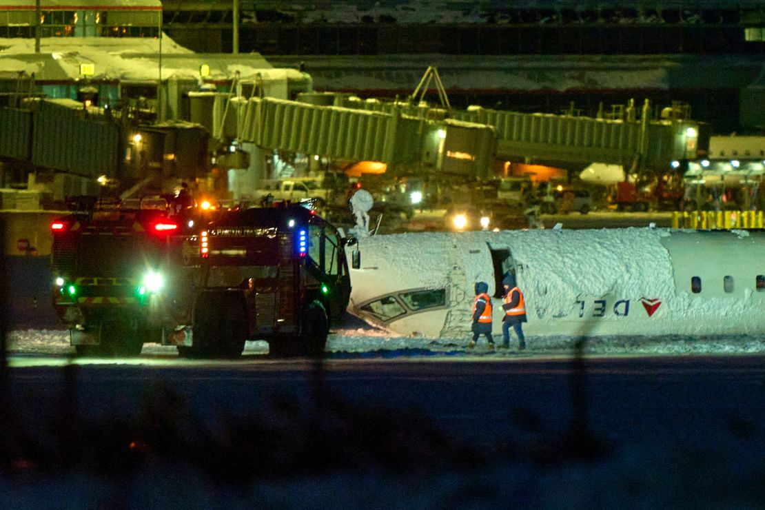 The plane sits on its roof after crashing at Toronto Pearson Airport on Monday.