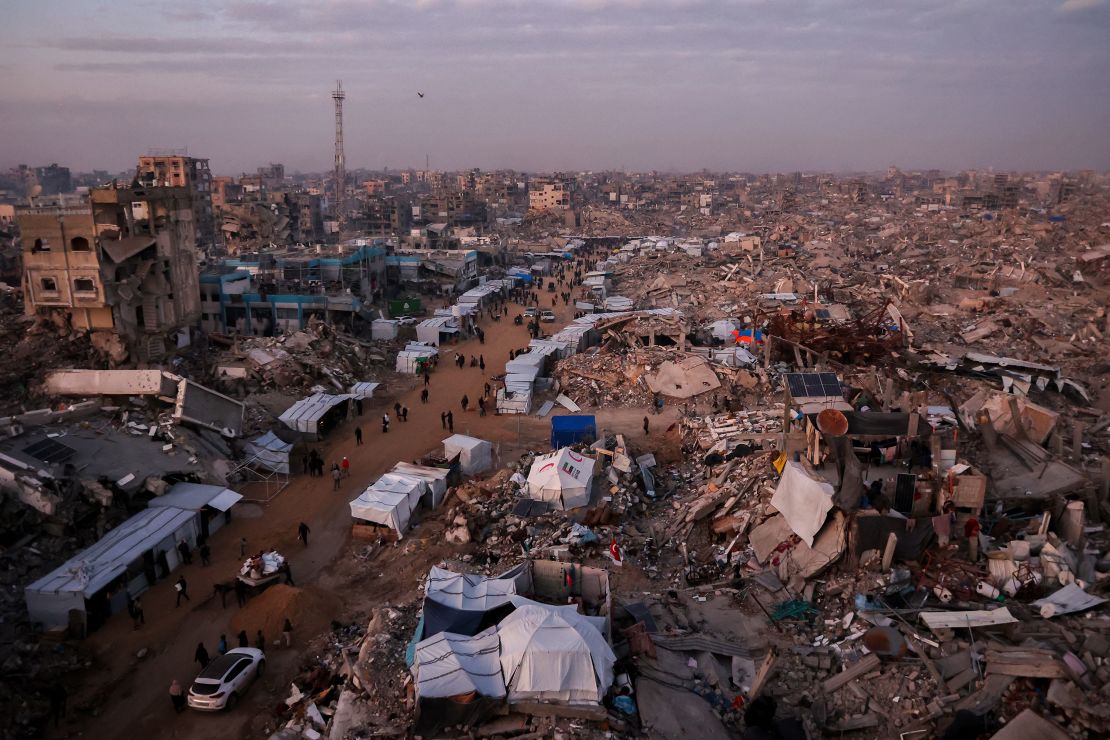 Palestinians walk past tents lining the streets amid the rubble of destroyed buildings in Jabalia, in the northern Gaza Strip on February 18.