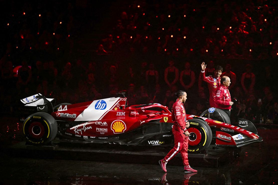 Hamilton walks out on stage with the new Ferrari car, alongside team principal Frédéric Vasseur and driver Charles Leclerc.