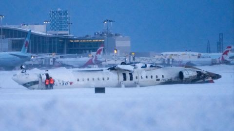 Los trabajadores del aeropuerto inspeccionan el lugar donde se estrelló un avión de Delta Air Lines en el Aeropuerto Internacional Pearson de Toronto el 18 de febrero, donde resultaron heridos al menos 18 pasajeros. Ninguno de los pasajeros ni la tripulación murieron en el accidente.