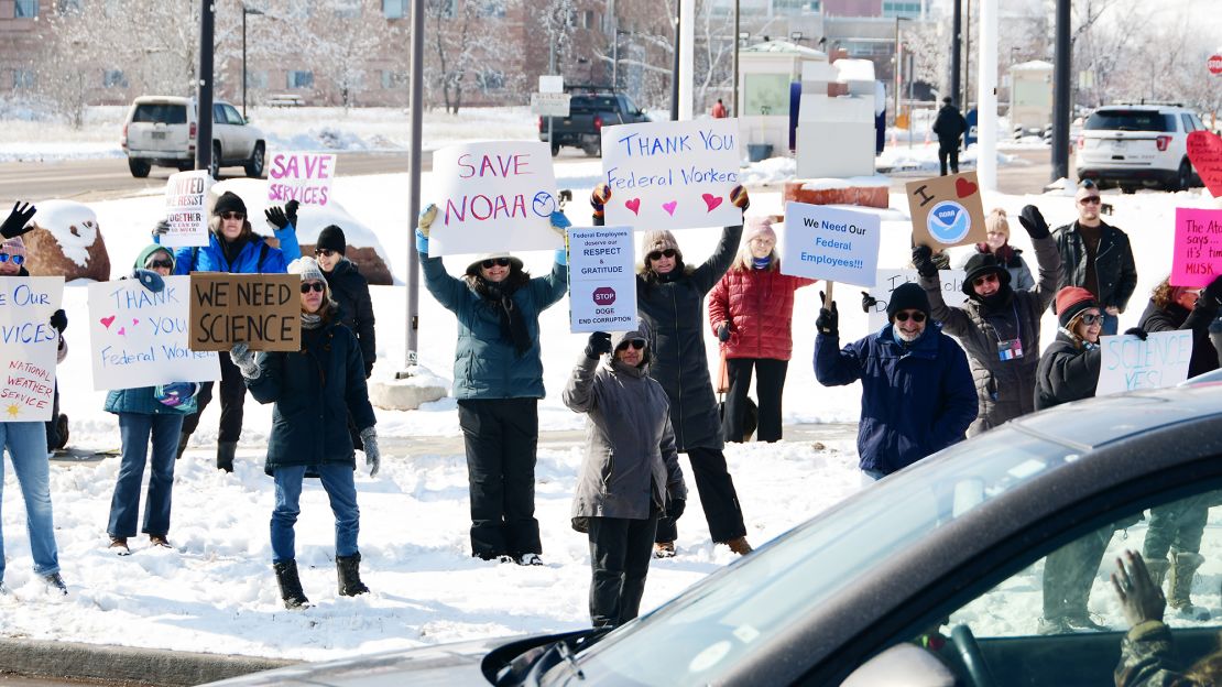 Federal workers and citizens concerned about a reduction in services gathered for a protest against cuts in the federal workforce in front of the US Department of Commerce's office in Boulder, Colorado, on February 19.