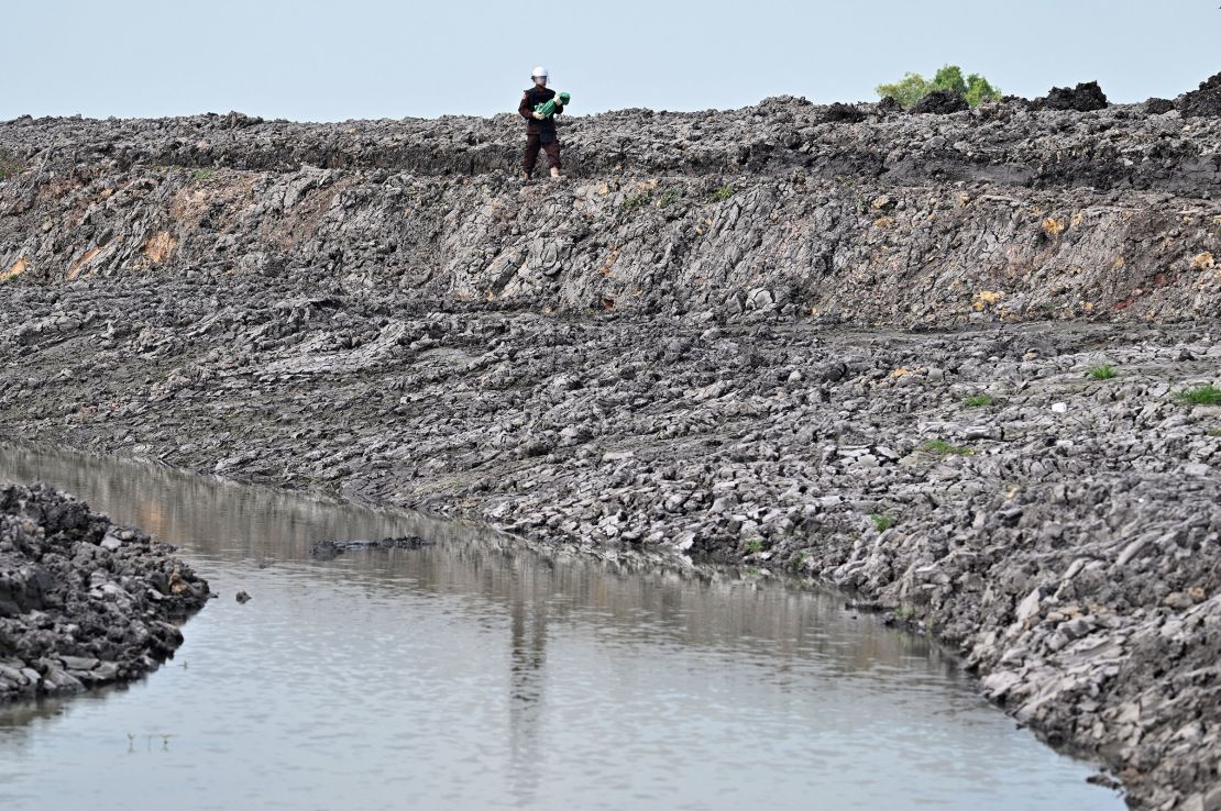 A deminer from the Cambodian Mine Action Centre carries an unexploded ordnance that was unearthed by a worker during irrigation work in Svay Rieng province, Cambodia, on February 11. Parts of Cambodia are still littered with unexploded munitions from decades of conflict.