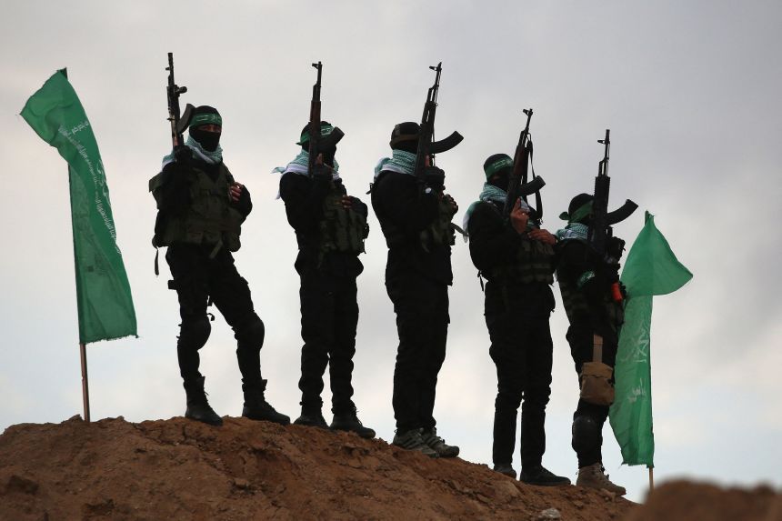 Palestinian Hamas militants gather at the site of the handing over of the bodies of four Israeli hostages in Khan Younis in the southern Gaza on February 20, 2025.