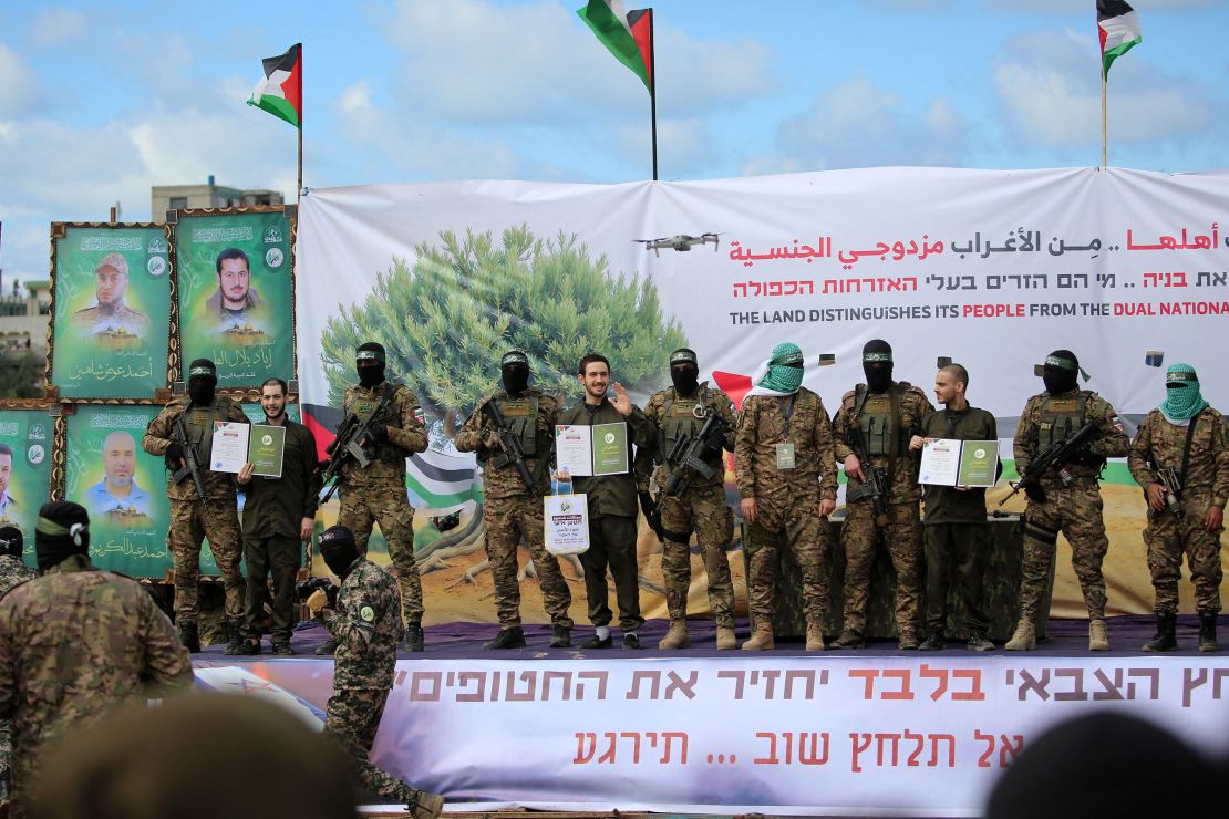 Hamas militants hand hostages Eliya Cohen, Omer Shem Tov and Omer Wenkert over to the Red Cross in central Gaza on February 22.