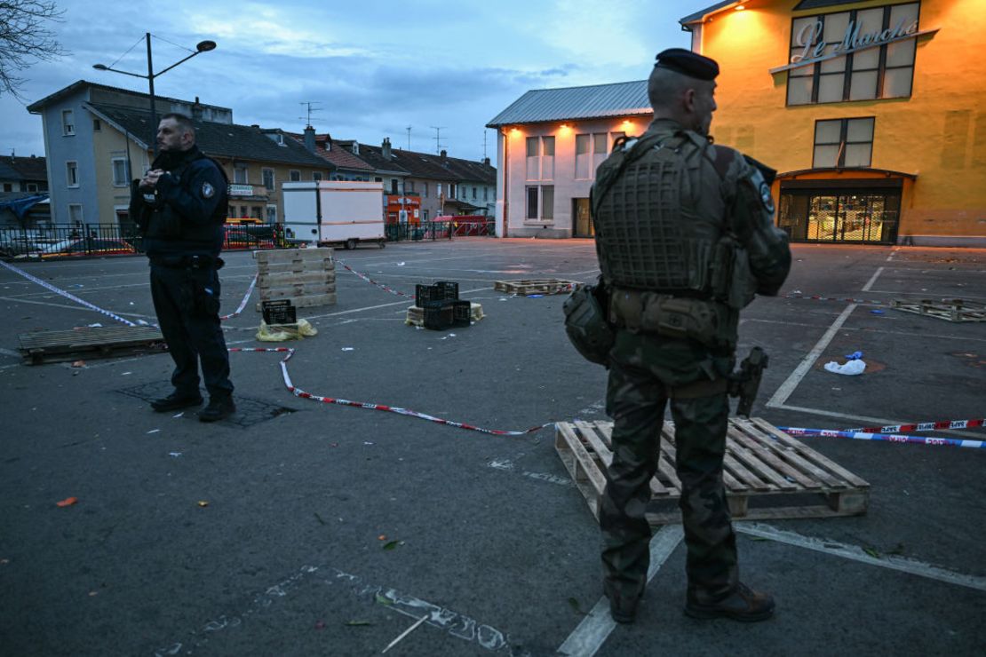 Un agente de policía y un militar hacen guardia en el lugar de un ataque con arma blanca en el que un hombre es sospechoso de matar a una persona y herir a policías municipales en Mulhouse, al este de Francia, el 22 de febrero de 2025.