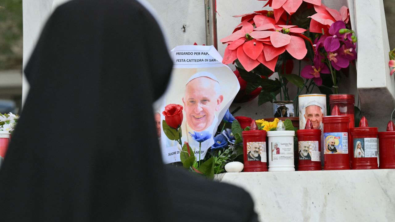Nun pray at the statue of John Paul II outside the Gemelli hospital where Pope Francis is hospitalized for pneumonia, in Rome on February 23, 2025. Pope Francis had a quiet night in hospital, the Vatican said on February 23, 2025, the morning after revealing the 88-year-old was in a "critical" condition. "The night ed peacefully, the pope rested," the Holy See said in a short update. (Photo by Alberto PIZZOLI / AFP) (Photo by ALBERTO PIZZOLI/AFP via Getty Images)          