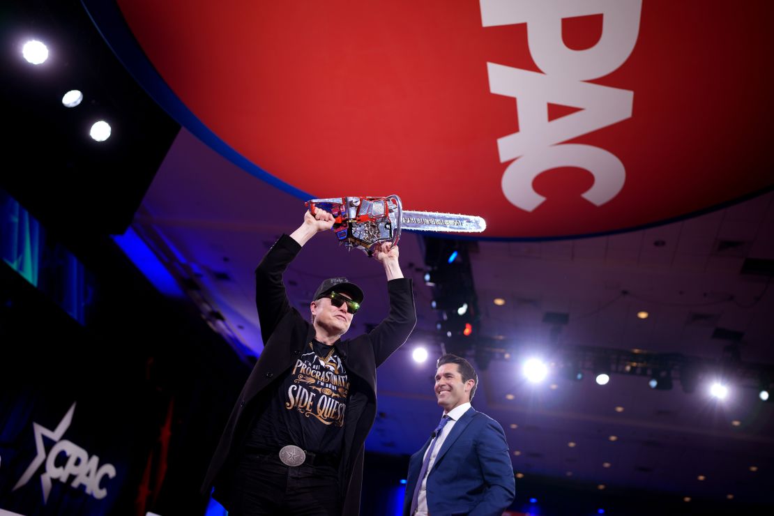 Elon Musk balanceará su motosierra cuando sale del escenario junto con el presentador de Newsmax Rob Schmitt (CPAC) en el Centro de Convenciones y Hotel National Resort Hotel en Oxon Hill, Maryland, el 20 de febrero de 2025.