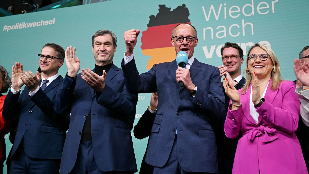 Friedrich Merz (R), leader of Germany's conservative Christian Democratic Union (CDU) and his party's main candidate for chancellor, reacts as he addresses supporters next to Bavaria's State Premier and Leader of the conservative Christian Social Union (CSU) Markus Soeder (2L), CDU Secretary General Carsten Linnemann (L) and CDU Vice-Secretary General Christina Stumpp (R) after the first exit polls in the German general elections were announced on TV during the electoral evening in Berlin on February 23, 2025. (Photo by INA FASSBENDER / AFP) (Photo by INA FASSBENDER/AFP via Getty Images)          