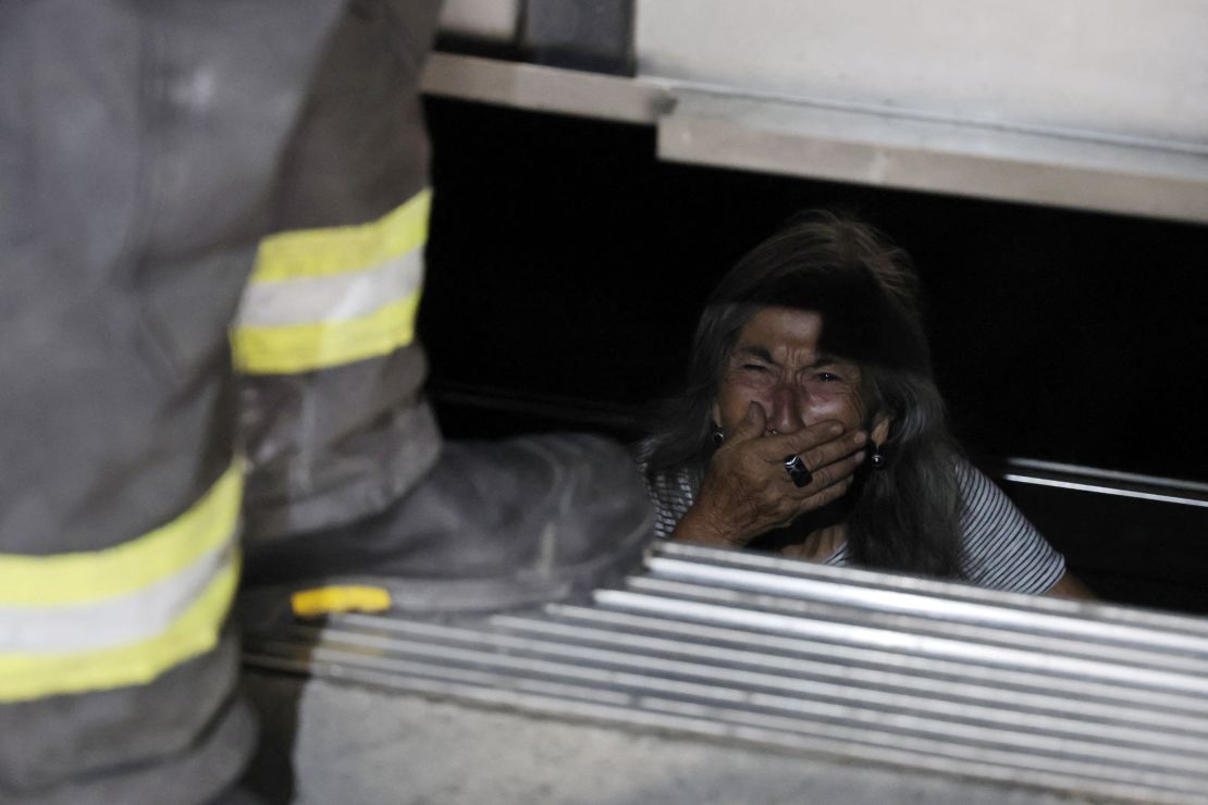 Una persona mayor atrapada en un ascensor reacciona mientras los bomberos ayudan en su rescate durante un apagón en Santiago el 25 de febrero de 2025.