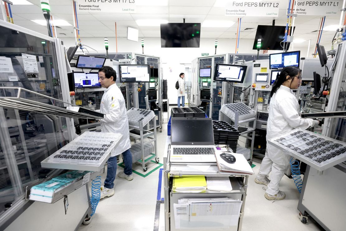 Workers assemble electronic car keys at a manufacturing plant in Mexico.