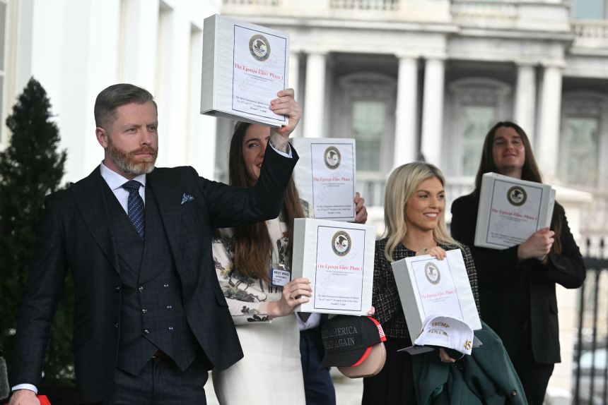 From left: Political commentator Rogan O'Handley, TikToker Chaya Raichik, commentator Liz Wheeler and conservative activist Scott Presler carry binders bearing the seal of the US Justice Department reading 