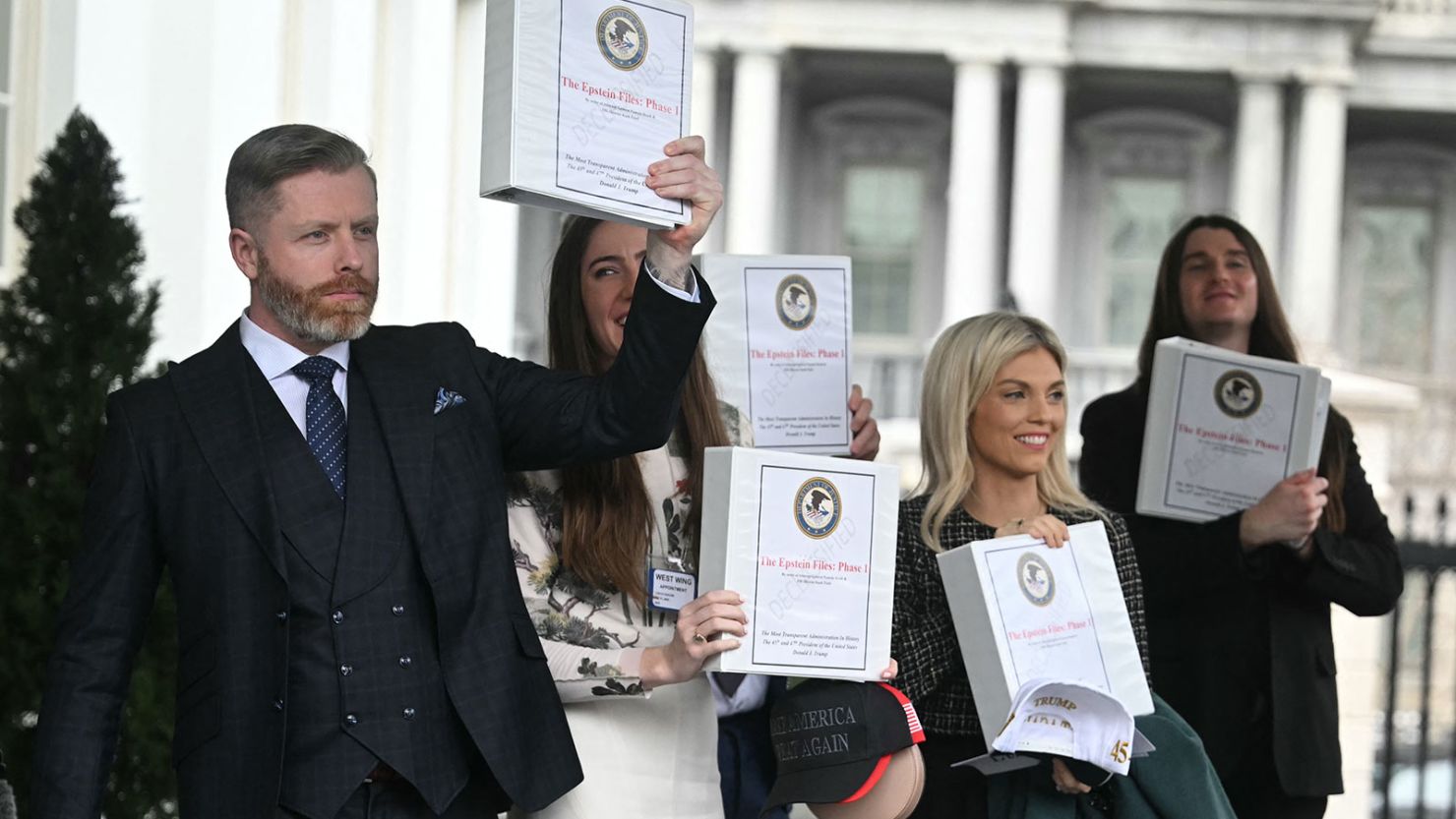From left: Political commentator Rogan O'Handley, aka DC Draino; TikToker Chaya Raichik; commentator Liz Wheeler; and US conservative activist Scott Presler carry binders bearing the seal of the US Justice Department reading, "The Epstein Files: Phase 1," as they walk out of the West Wing of the White House in Washington, DC, on Thursday.