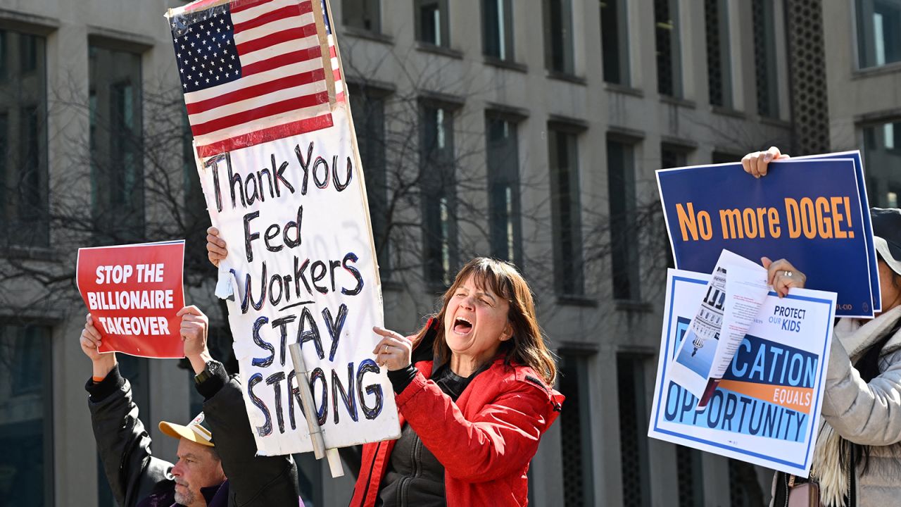 Protesters hold signs in solidarity with the American Federation of Government Employees of District 14 at a rally in support of federal workers at the Office of Personnel Management in Washington, DC, March 4, 2025.