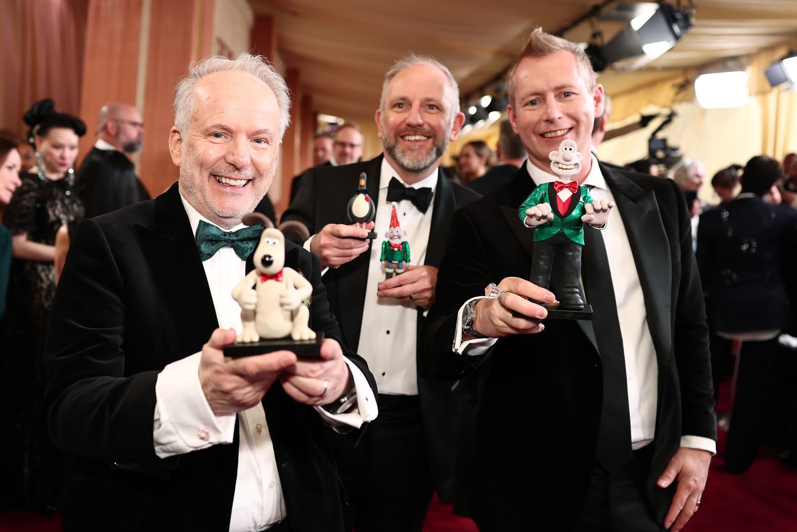 From left, Nick Park, Richard Beek and Merlin Crossingham hold "Wallace & Gromit" figurines before the show. Park and Crossingham directed "Wallace & Gromit: Vengeance Most Fowl," which was nominated for best animated feature. Beek produced the film.