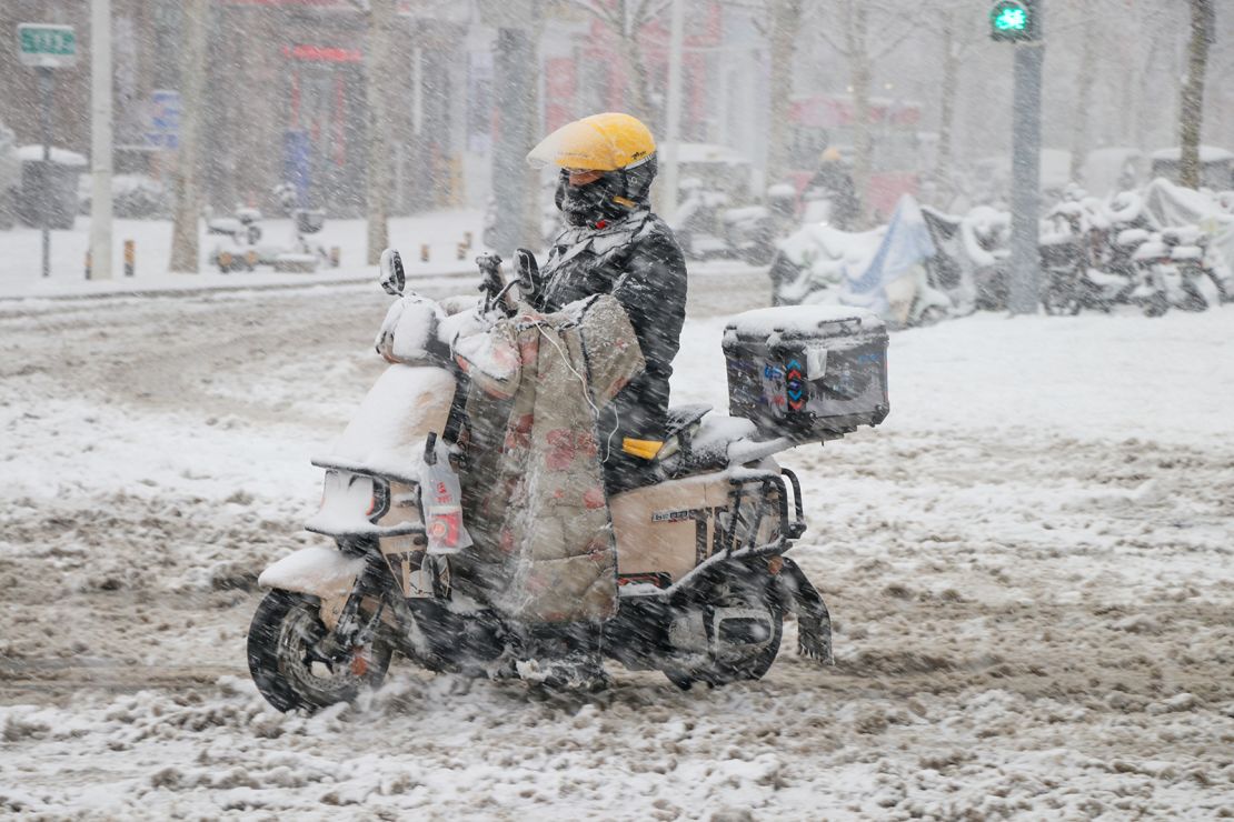 A deliveryman rides in snow on March 2, 2025 in Jinan, Shandong province of China.