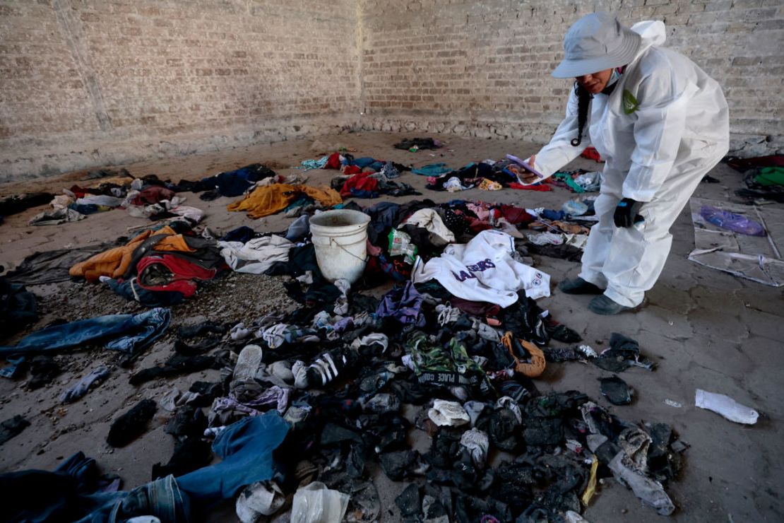 Una mujer graba ropa y zapatos encontrados en el Rancho Izaguirre en la comunidad La Estanzuela, donde el colectivo 'Guerreros Buscadores' encontró tres crematorios humanos mientras buscaban a sus familiares en Teuchitlán, estado de Jalisco, México, el 5 de marzo de 2025.
