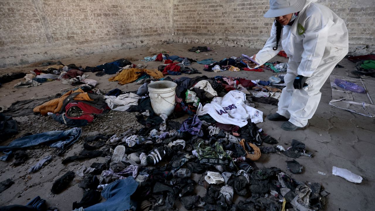 TOPSHOT - A woman records clothes and shoes found at the Izaguirre Ranch in the community La Estanzuela where the collective 'Guerreros Buscadores' located three human crematoriums while searching for their relatives in Teuchitlan, Jalisco state, Mexico on March 5, 2025. According to local authorities the Izaguirre Ranch was used by organized crime to train new . (Photo by ULISES RUIZ / AFP) (Photo by ULISES RUIZ/AFP via Getty Images)          