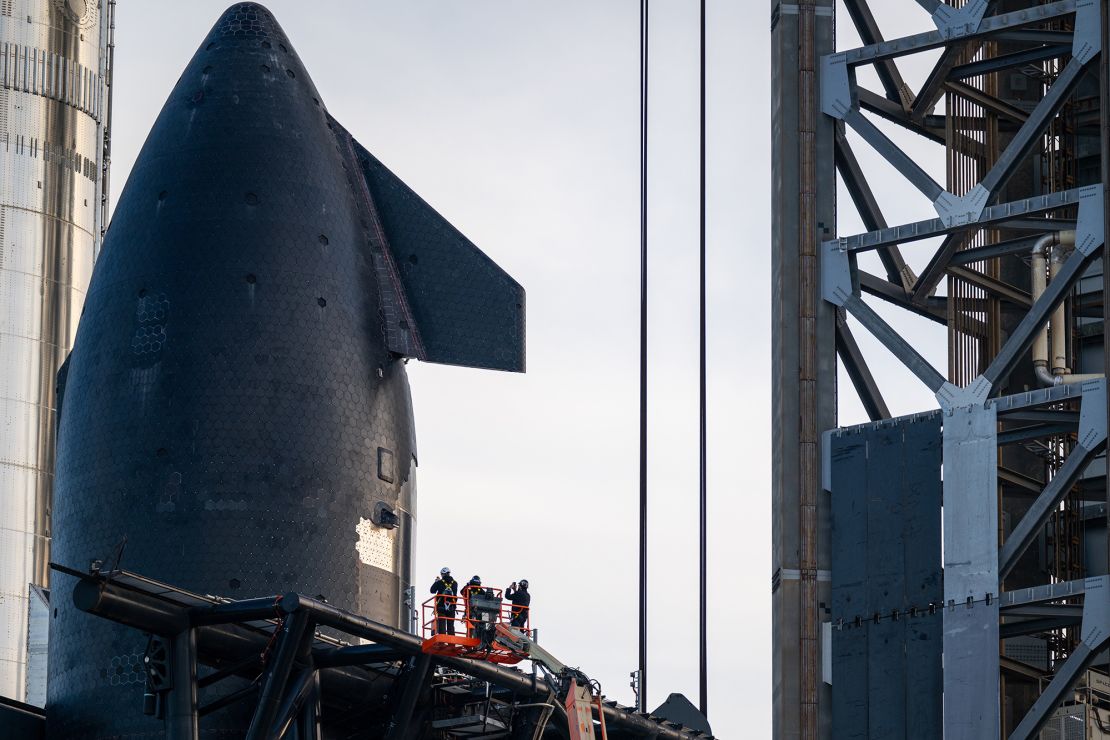 Workers survey the SpaceX Starship rocket on March 3 ahead of its eighth uncrewed test flight.