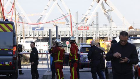 French police officers, next to firefighters, block the access to the SNCF's freight area in Saint-Denis, northern suburb of Paris on March 7, 2025, following the discovery of a World War II bomb. Railway services at the Gare du Nord station, that have been interrupted on March 7, 2025 morning after the discovery of a World War II bomb, will remain "highly disrupted throughout the day", warned the Minister for Transport. (Photo by GEOFFROY VAN DER HASSELT / AFP) (Photo by GEOFFROY VAN DER HASSELT/AFP via Getty Images)          