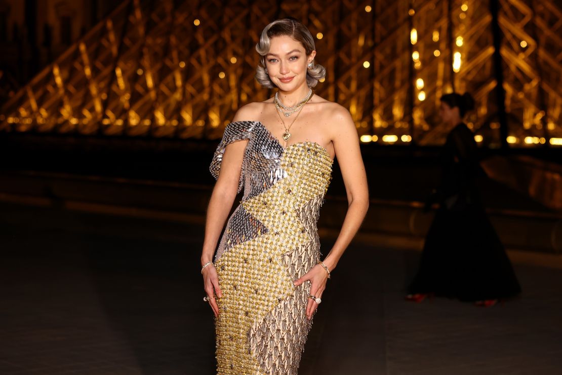 Wearing a gold Moschino dress, model Gigi Hadid exuded glamour at the Louvre.